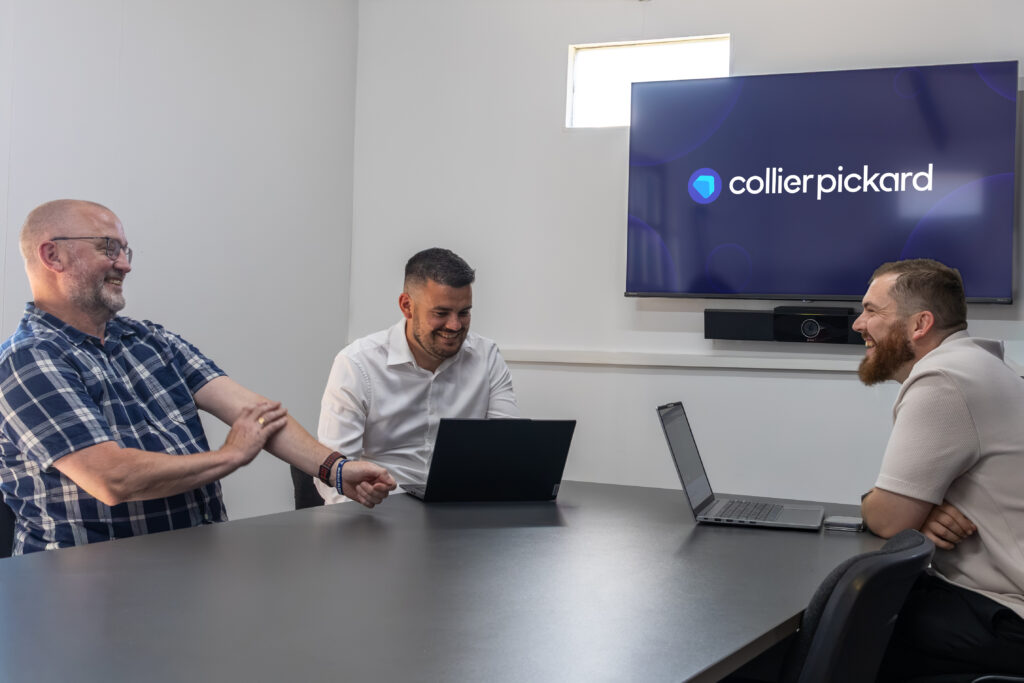 Thee CRM consultants meet around a table at Collier Pickard.