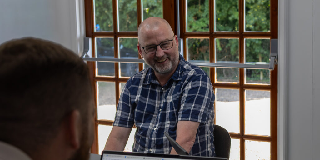 Steve Robertson Laughing at Collier Pickard Meeting Room wide