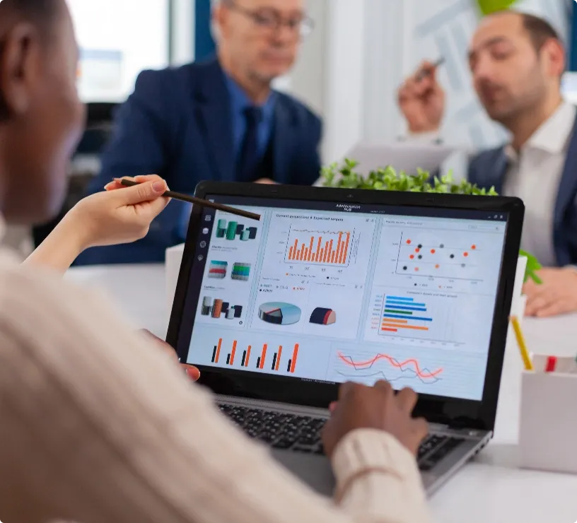 Two people looking a statistics and graphs on a laptop screen