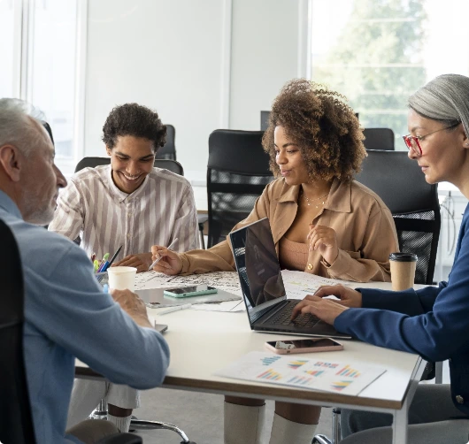 People in a group working around a table.